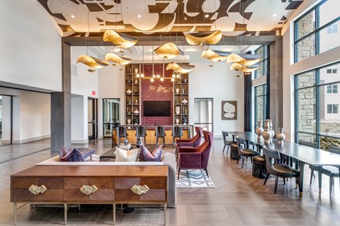 a lobby with a long table with chairs and a reception desk